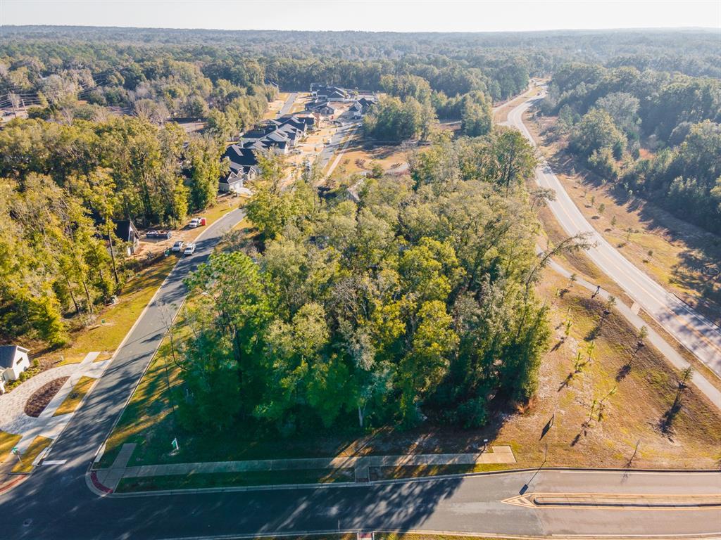 An aerial view shows a wooded residential lot situated between two paved roads — 14117 SW 7TH PLACE, NEWBERRY, FL