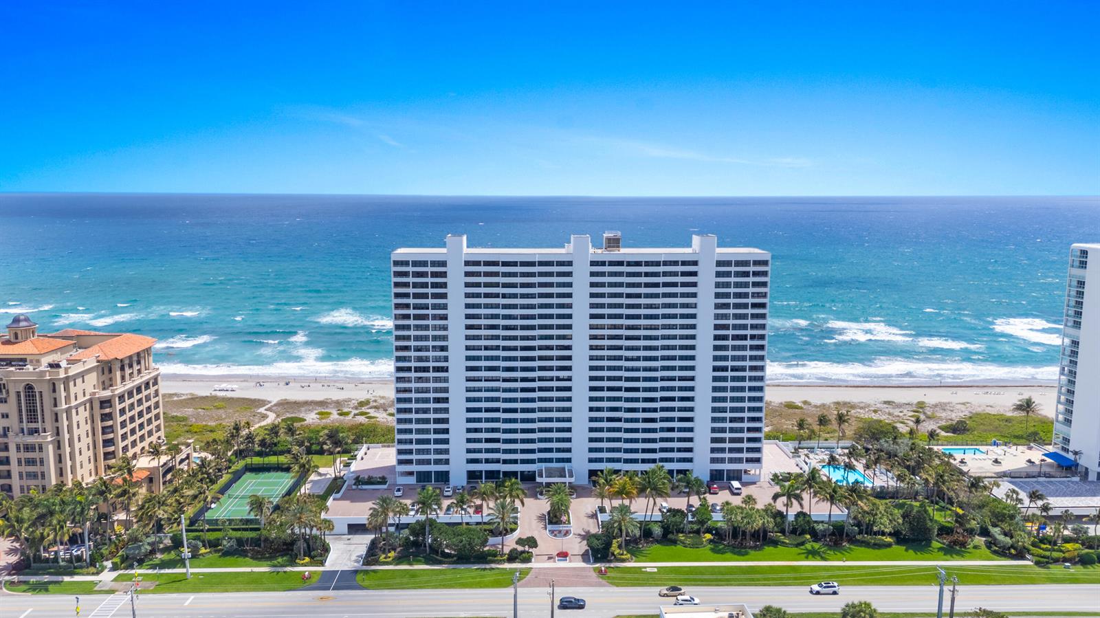 An aerial view shows a tall white residential building situated directly on a sandy beach — 2600 S Ocean Boulevard, Boca Raton FL 33432, BOCA RATON, FL