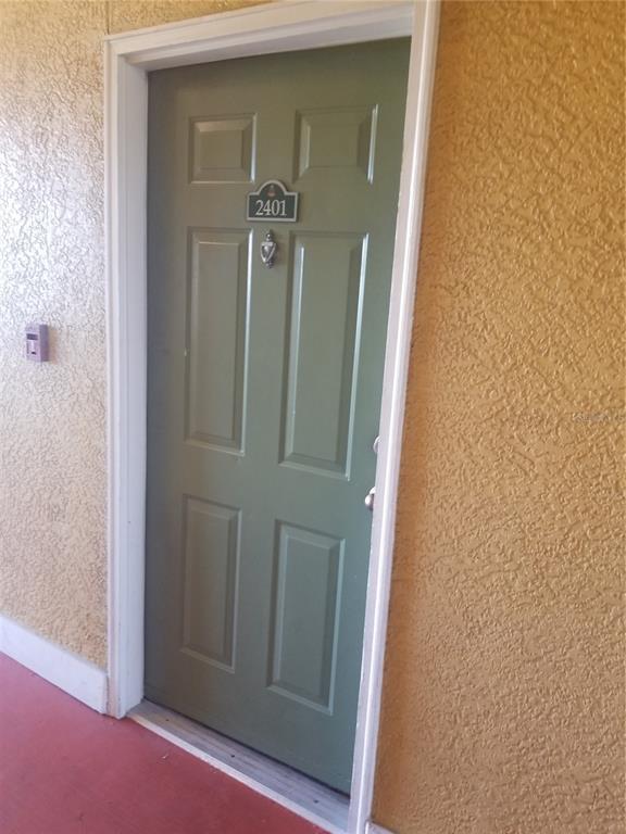 A green front door with a silver knocker and the number 2401 is set in a textured wall — 4207 S DALE MABRY HIGHWAY UNIT 2401, TAMPA, FL