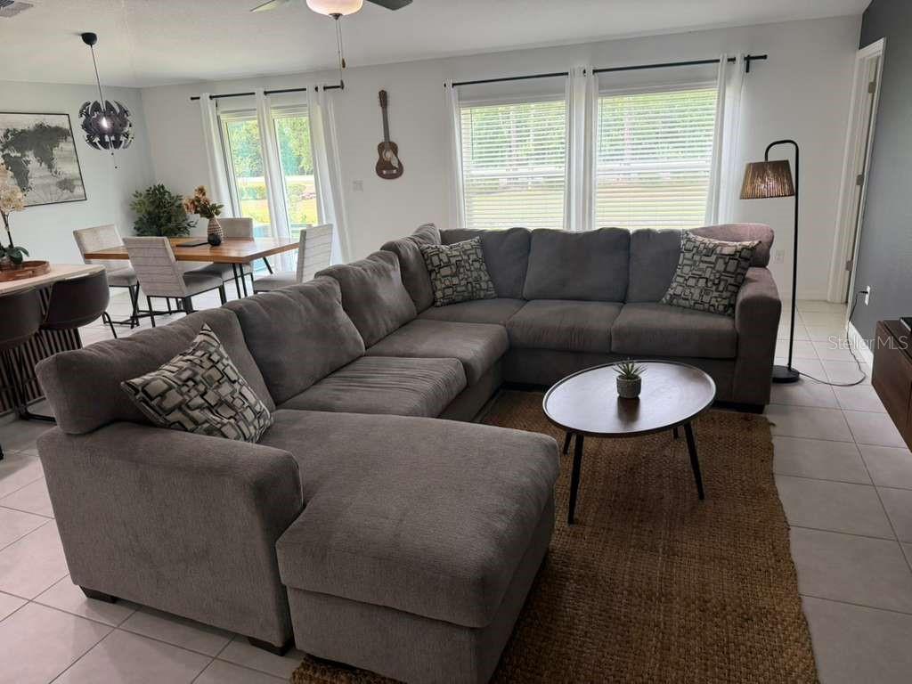 A living room features a large gray sectional sofa, a round coffee table, and a dining area — 2000 RED LOOP, LAKELAND, FL