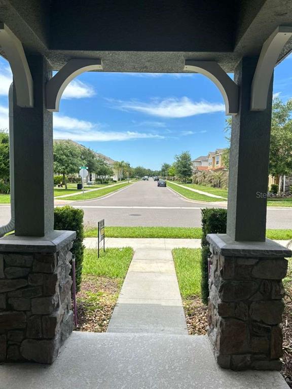 A view from a covered front porch looking out toward a suburban residential street — 9031 LEGADO DRIVE, WINDERMERE, FL