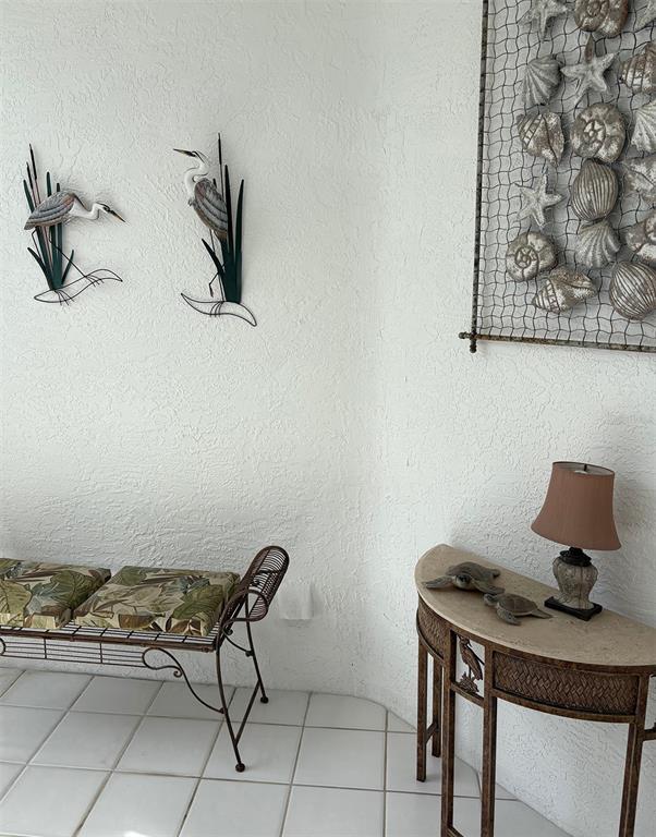 A corner of a room features a bench, a console table, and coastal wall decor — 1303 ISLAMORADA BOULEVARD, PUNTA GORDA, FL
