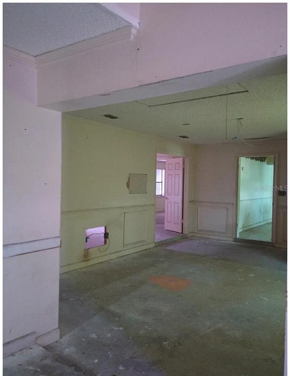 An interior view of a room with beige walls, wainscoting, and an exposed wall opening — 1882 BANKS ROAD, LAKE WALES, FL