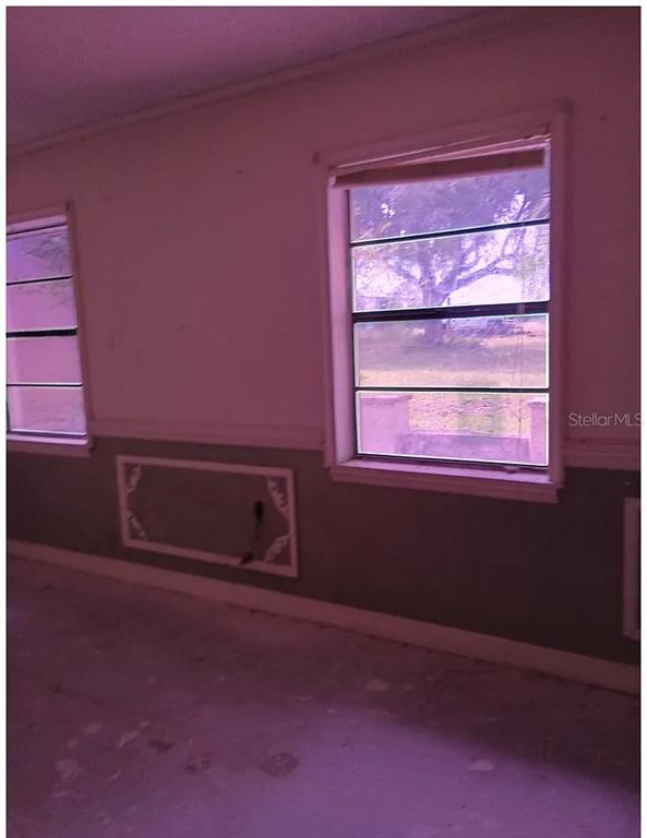 An interior room features two windows, light-colored walls, and a decorative rectangular wall panel — 1882 BANKS ROAD, LAKE WALES, FL