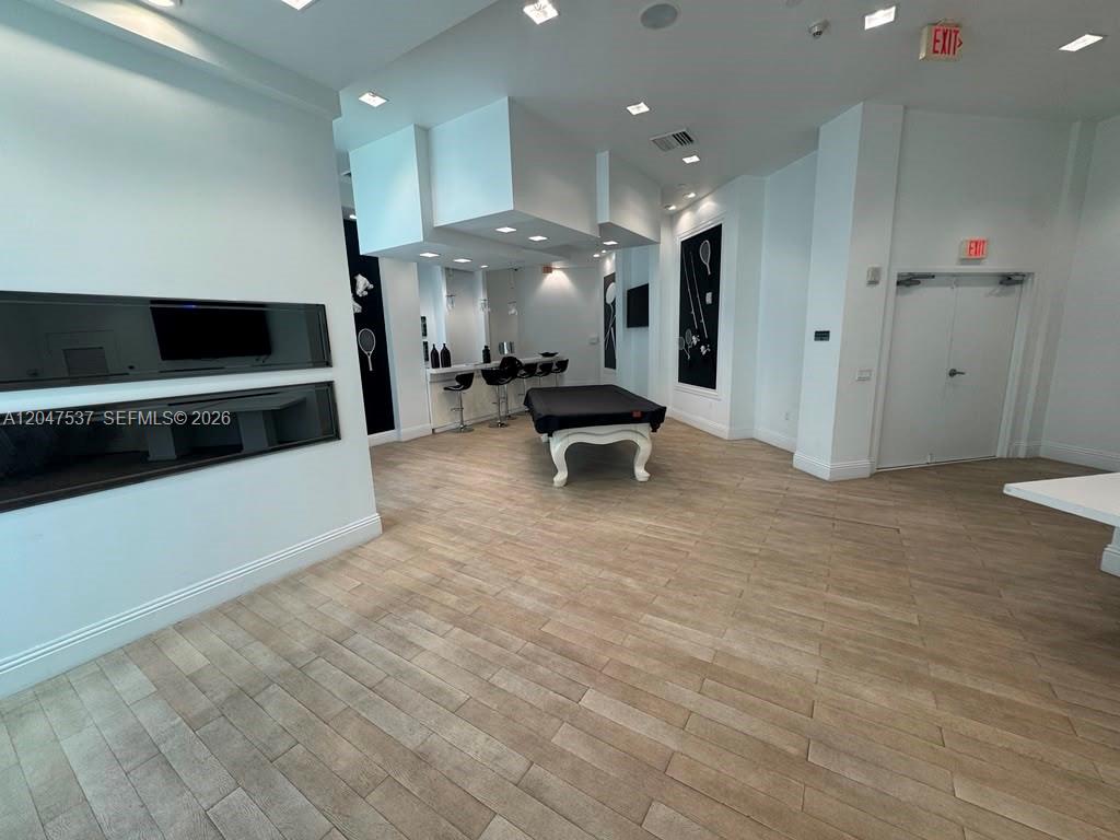A game room features a pool table, a bar area, and light wood-look tile flooring — 350 S Miami Ave # 3304, Miami FL 33130, MIAMI, FL