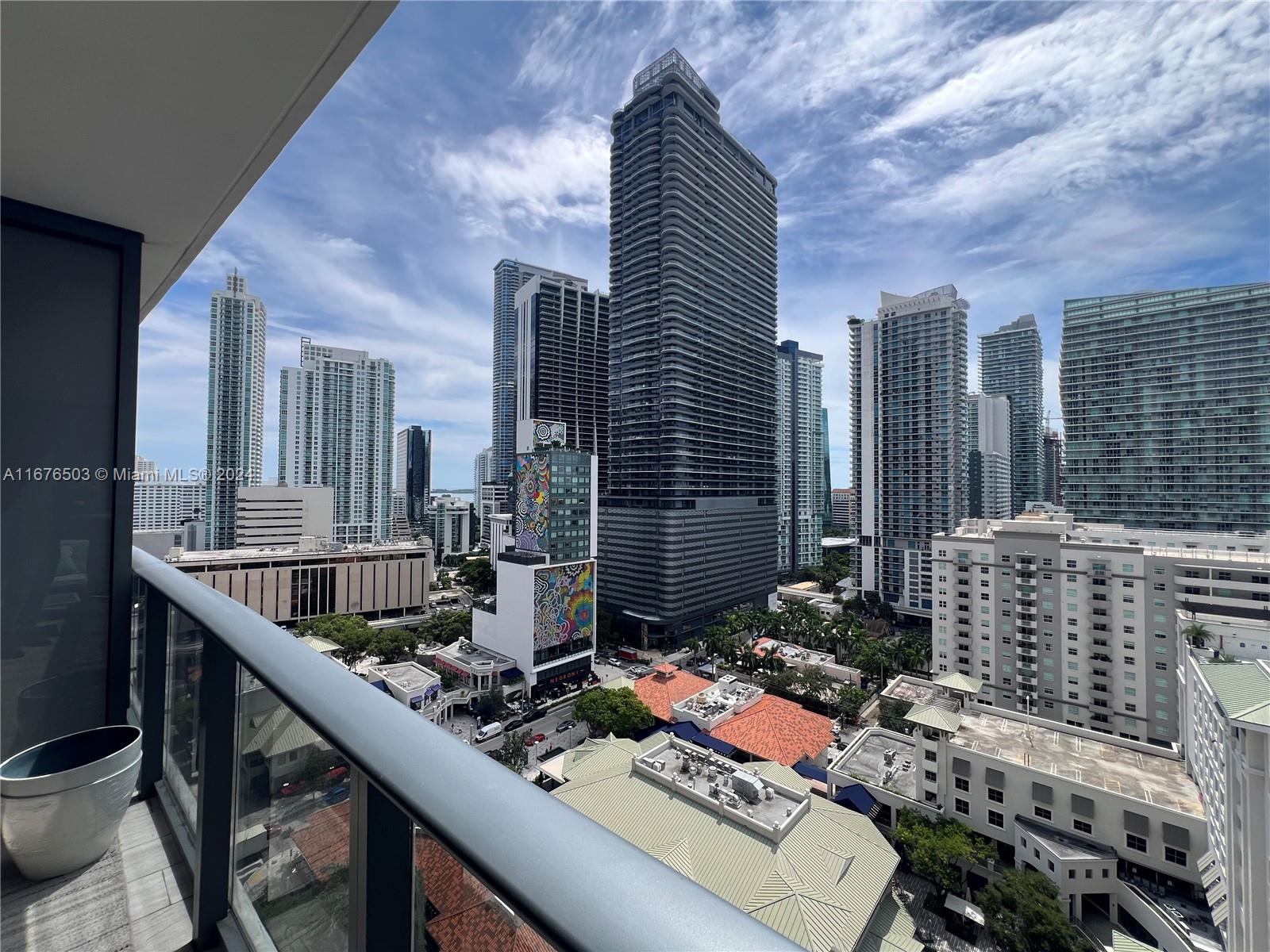 A balcony overlooks a dense urban skyline with numerous high-rise buildings and city streets — 55 SW 9th St # 1604, Miami FL 33130, MIAMI, FL