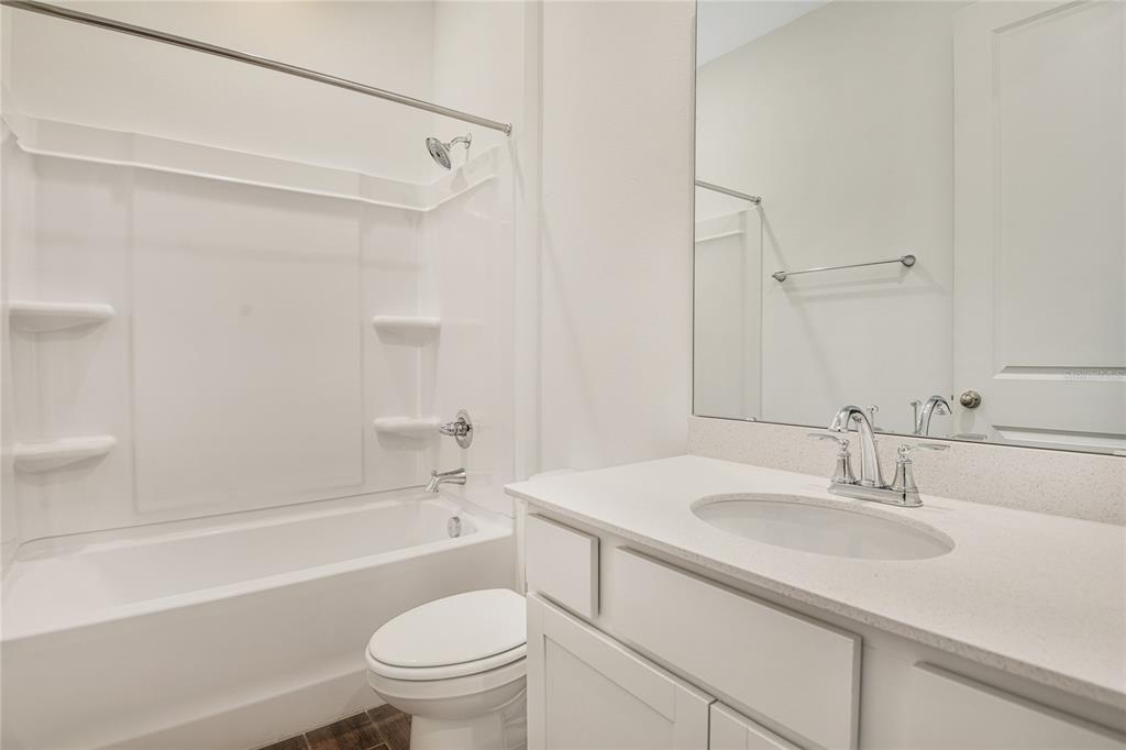 A bathroom features a white vanity, a toilet, and a shower-tub combination with white walls — 6155 SW 64TH TERRACE, OCALA, FL