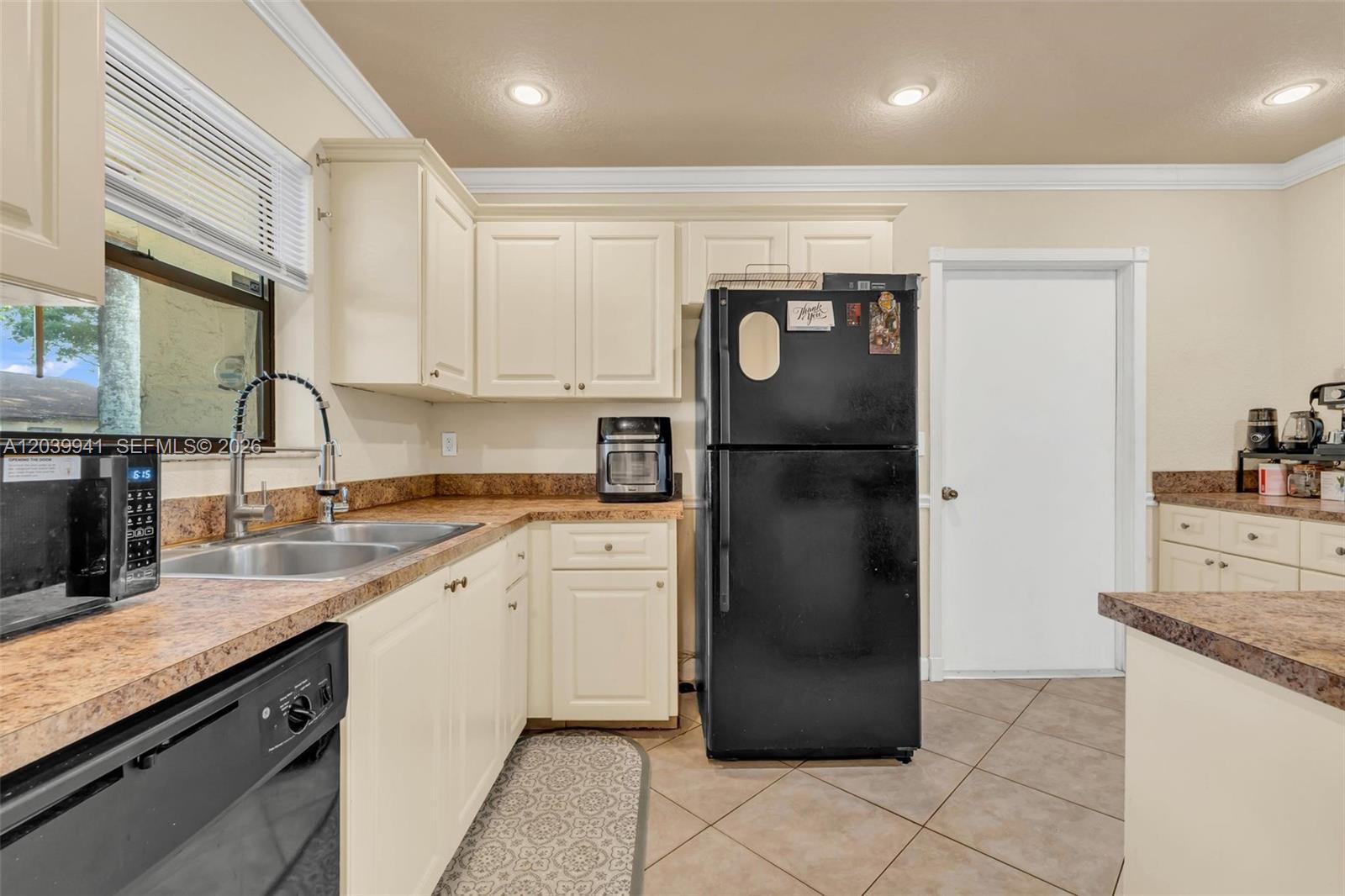 A kitchen features off-white cabinets, a black refrigerator, a double sink, and brown countertops — 6633 N Parkway Dr # 7, Margate FL 33068, MARGATE, FL