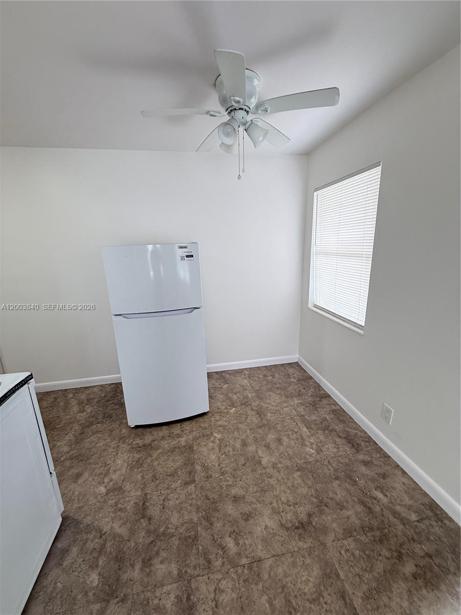 A room with a white refrigerator, a ceiling fan, and brown tile flooring — 801 N H St # 1, Lake Worth FL 33460, LAKE WORTH, FL