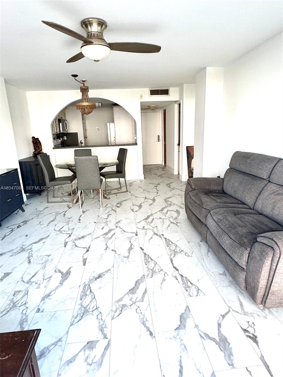 A living and dining area features white marble-look tile flooring and a ceiling fan — 600 NE 36th St # 609, Miami FL 33137, MIAMI, FL