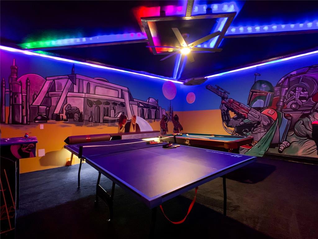 A game room features a ping pong table, a pool table, and Star Wars-themed wall murals — 3401 LILAC WAY, DAVENPORT, FL