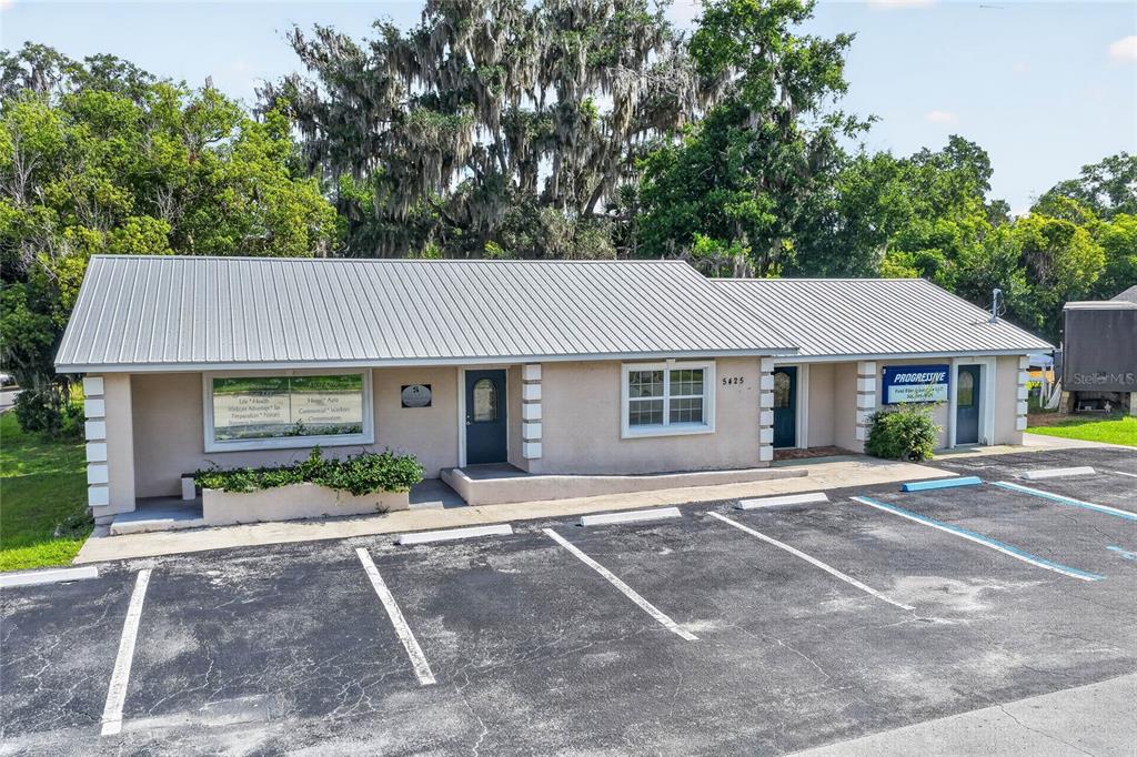A single-story commercial building with a metal roof and a paved parking lot in front — 5425 SE 111TH STREET, BELLEVIEW, FL
