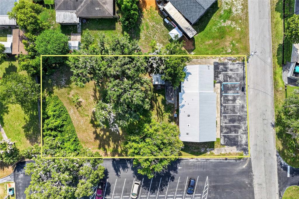 An aerial view shows a rectangular lot with a building, parking spaces, and large trees — 5425 SE 111TH STREET, BELLEVIEW, FL