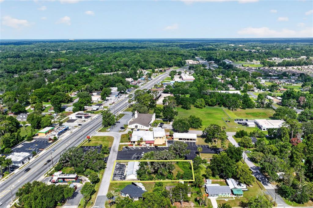 An aerial view shows a rectangular lot outlined in yellow near a commercial roadway — 5425 SE 111TH STREET, BELLEVIEW, FL