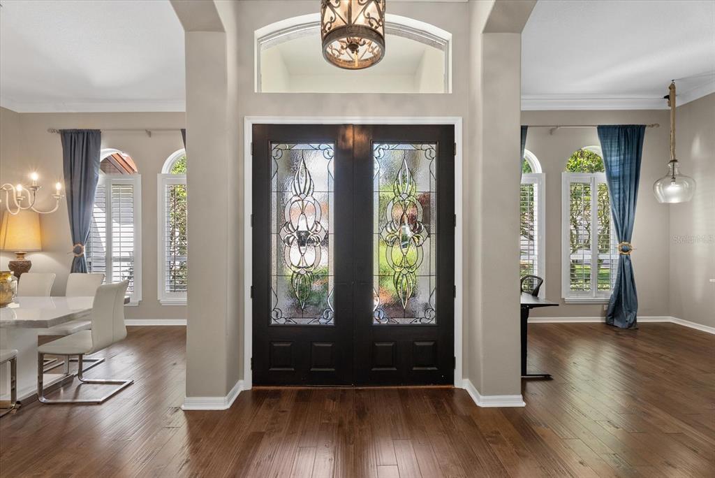 A foyer features dark wood floors, a double front door with glass inserts, and columns — 9145 HIGHLAND RIDGE WAY, TAMPA, FL