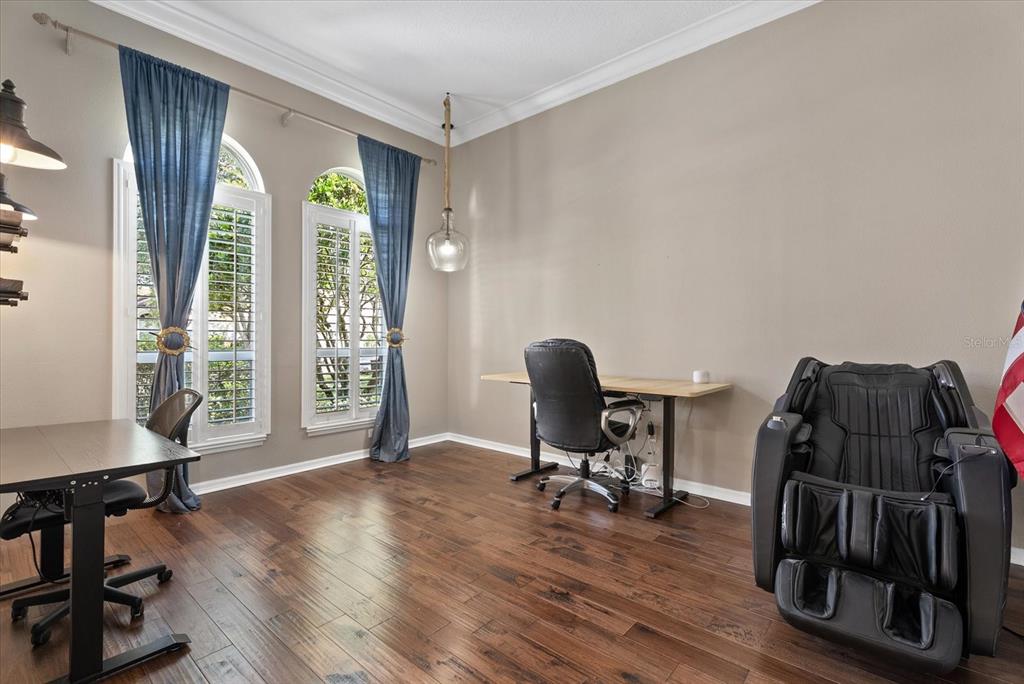 A home office features hardwood floors, two desks, a massage chair, and arched windows — 9145 HIGHLAND RIDGE WAY, TAMPA, FL