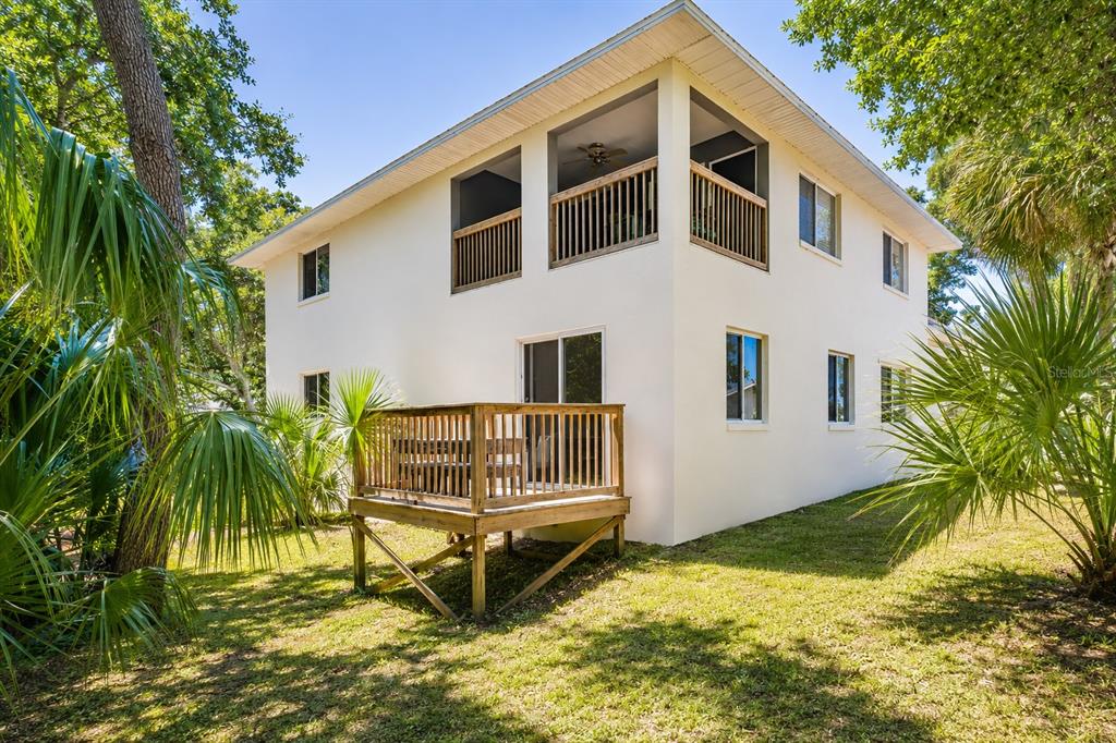 A two-story house with a wooden deck and a second-floor screened balcony — 601 E 2ND AVENUE, NEW SMYRNA BEACH, FL