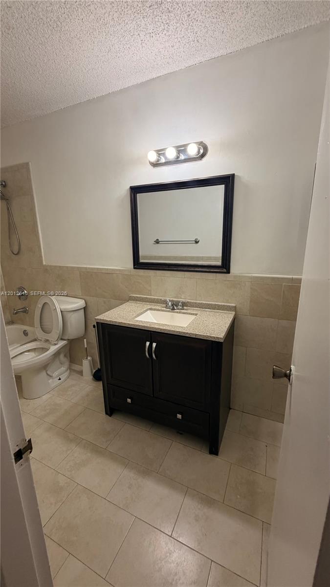 A bathroom features a dark wood vanity, a mirror, and a toilet next to a tub — 9972 SW 88th St # 1125, Miami FL 33176, MIAMI, FL