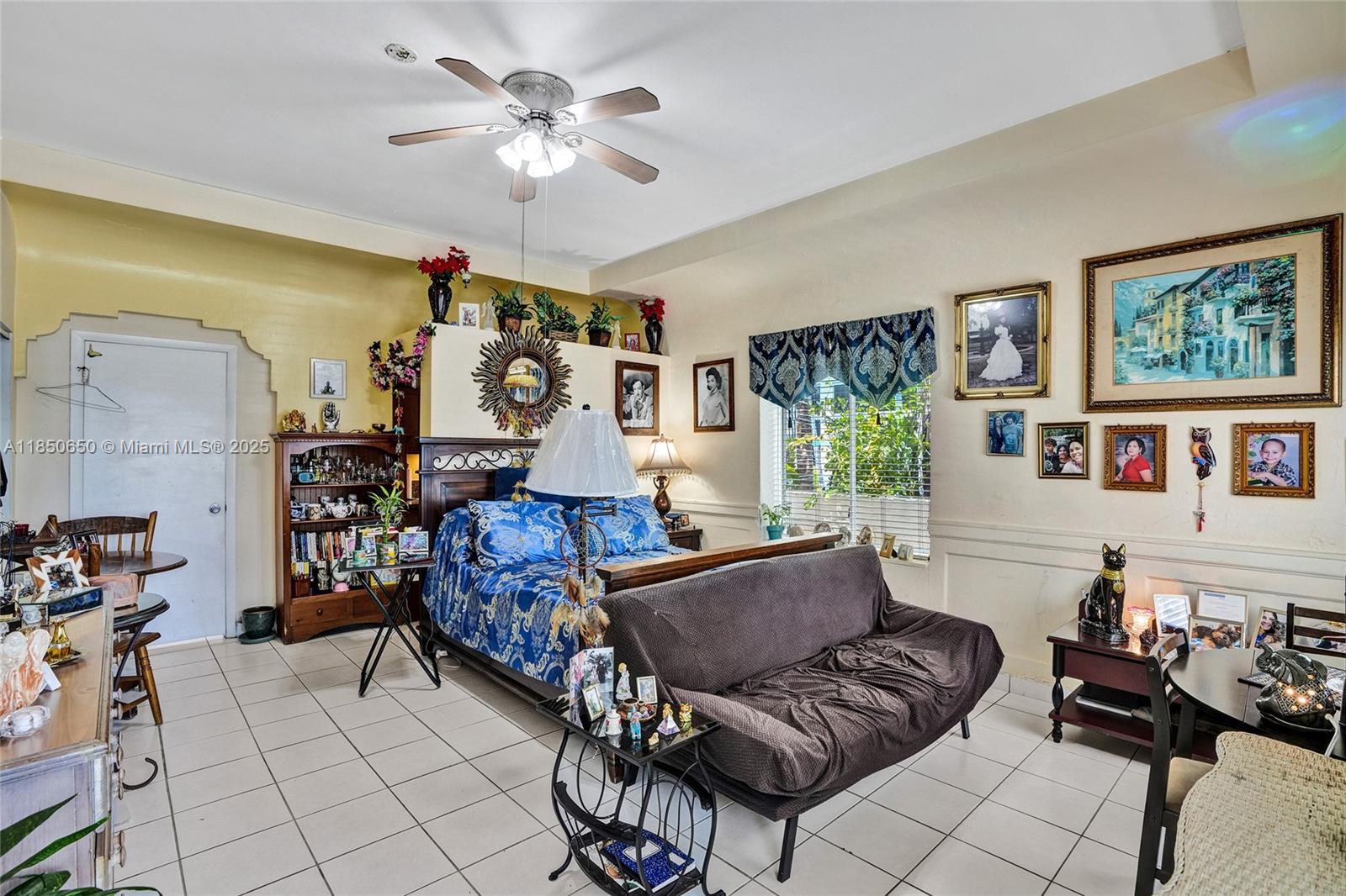 A bedroom features a bed, a futon, tiled floors, and various wall-mounted framed pictures — 3710 Collins Ave # 100, Miami Beach FL 33140, MIAMI BEACH, FL