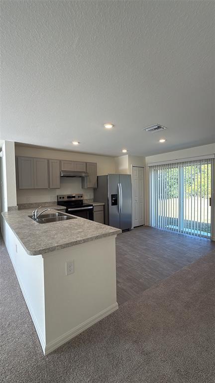 A kitchen with gray cabinets, stainless steel appliances, and a peninsula island with a sink — 18316 MONMOUTH AVENUE, PORT CHARLOTTE, FL