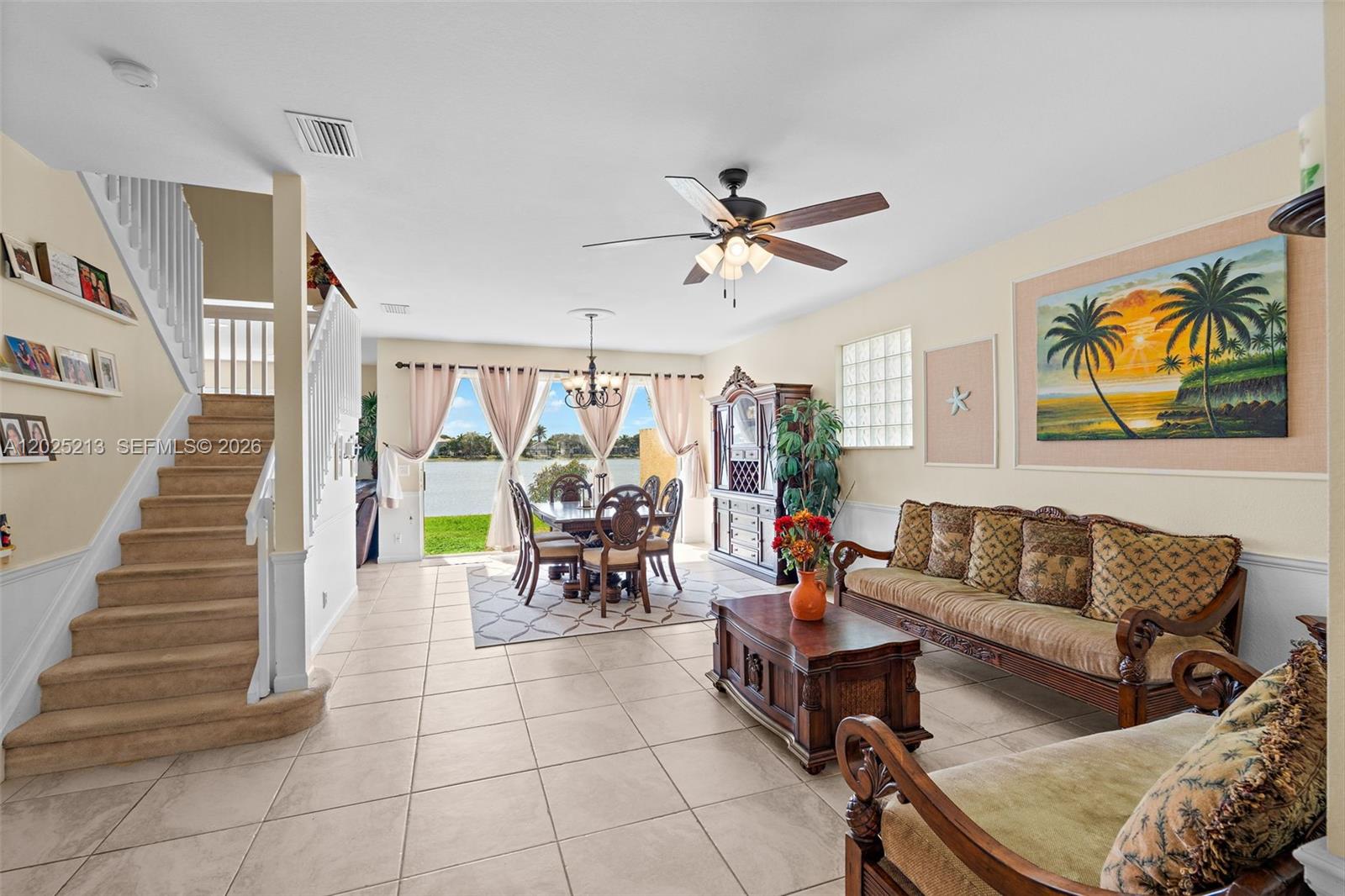 A living and dining area features tile floors, a staircase, and a view of water — 116 Berenger Walk, Royal Palm Beach FL 33414, ROYAL PALM BEACH, FL