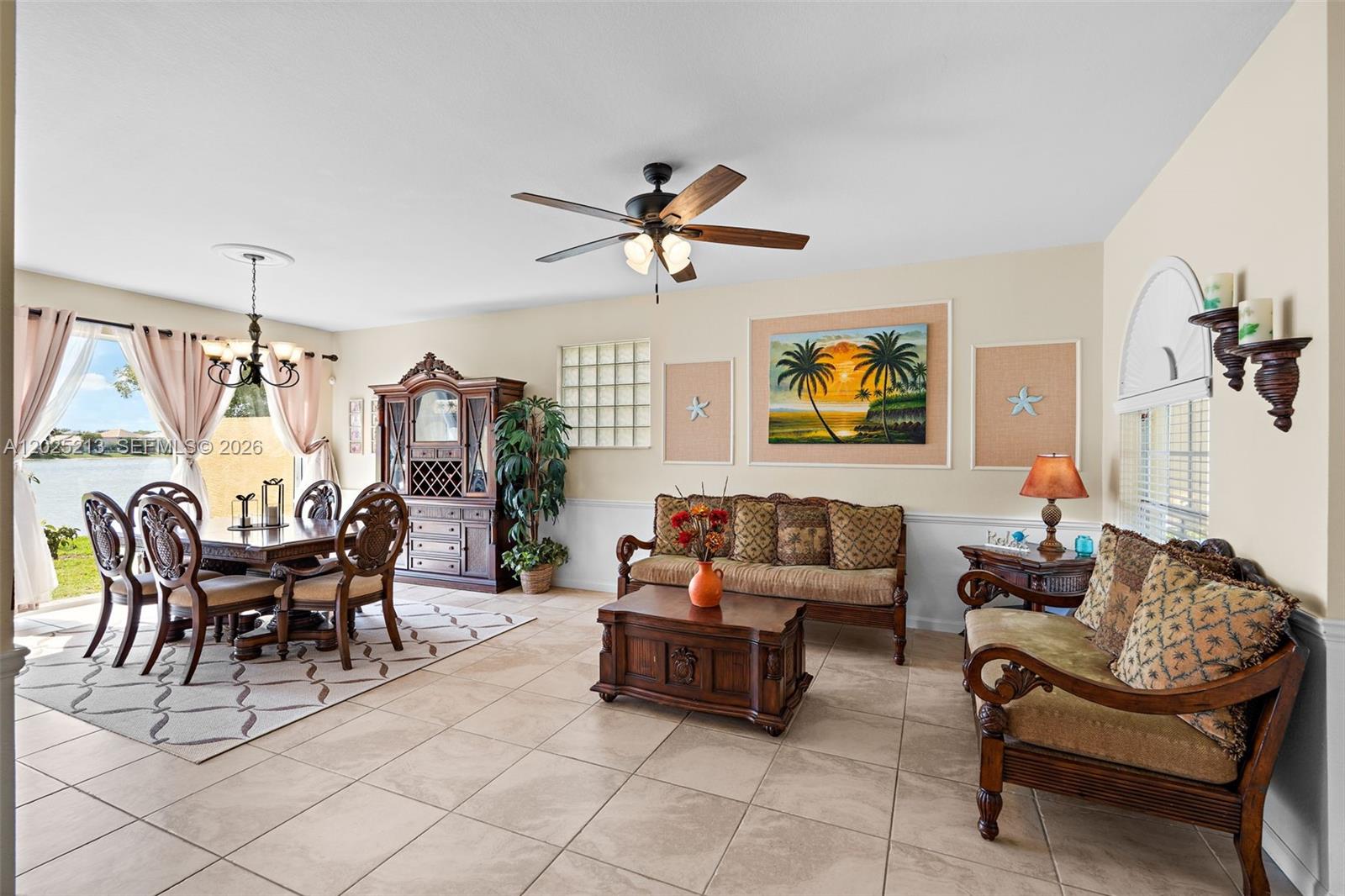 A living and dining room with tile floors, wooden furniture, and a view of water — 116 Berenger Walk, Royal Palm Beach FL 33414, ROYAL PALM BEACH, FL