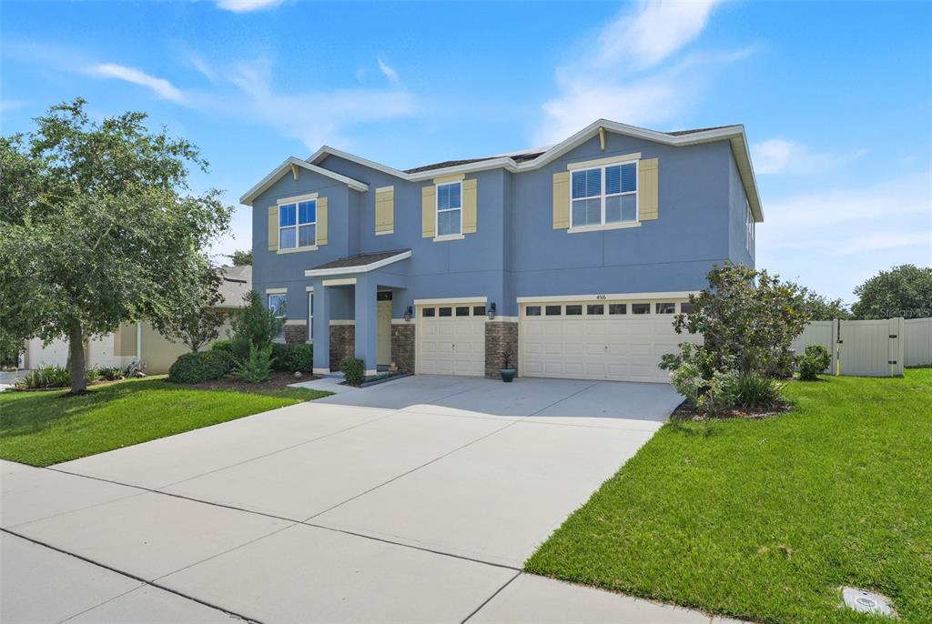 A two-story blue house with a three-car garage and a concrete driveway — 4516 LINWOOD TRACE LANE, CLERMONT, FL
