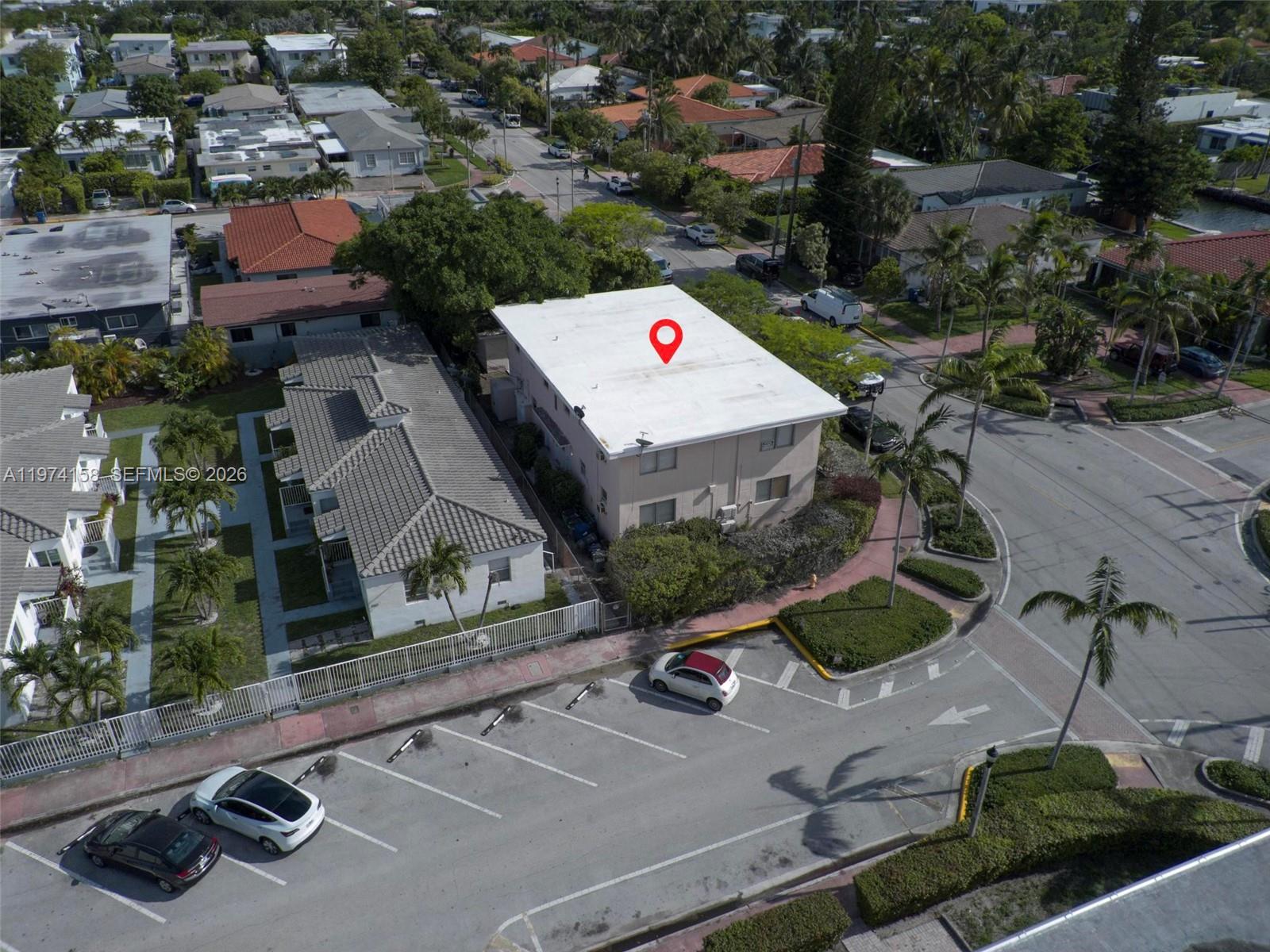 An aerial view shows a multi-story apartment building with a white roof and parking lot — 8031 Hawthorne Ave, Miami Beach FL 33141, MIAMI BEACH, FL