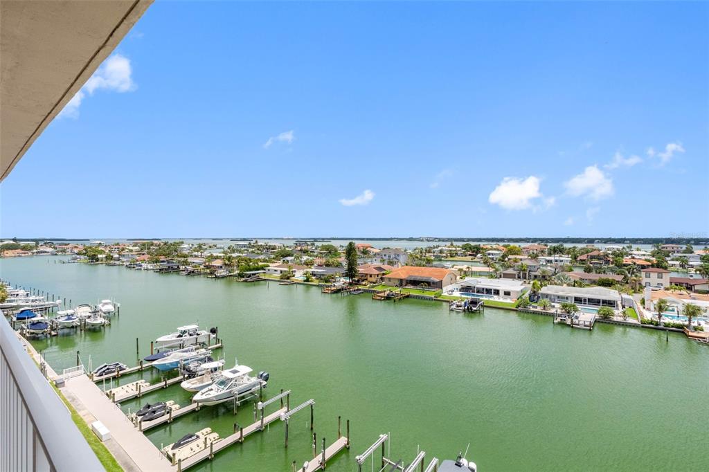 An elevated view of a canal with docked boats and residential homes under a blue sky — 223 ISLAND WAY UNIT 7F, CLEARWATER BEACH, FL