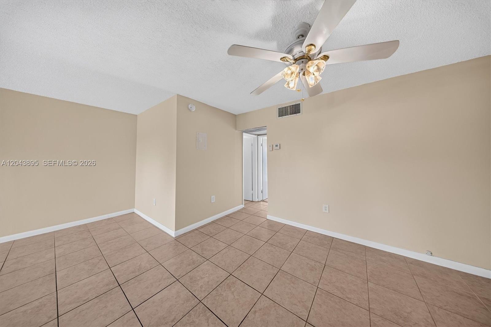 An empty room features beige walls, light-colored tile flooring, and a ceiling fan — 20311 NE 2nd Ave # 21, Miami FL 33179, MIAMI, FL