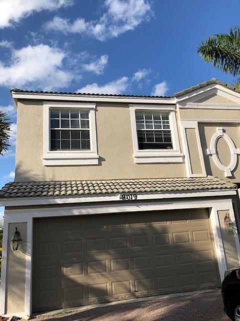 The exterior of a two-story house features a beige stucco facade and a two-car garage — 9019 Alexandra Circle, Wellington FL 33414, WELLINGTON, FL