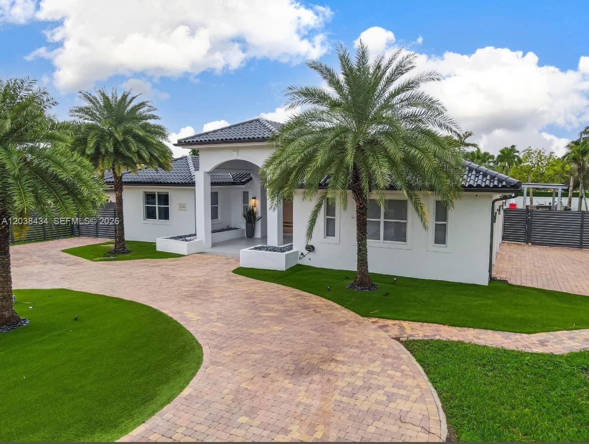 A white single-story house with a paved driveway, palm trees, and a green lawn — 11390 SW 30th St, Miami FL 33165, MIAMI, FL