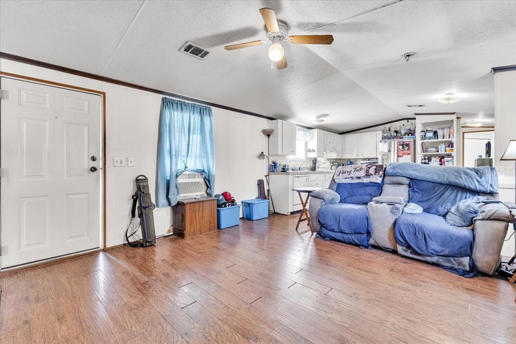A living room with wood-look flooring, a ceiling fan, and a blue sofa — 1169 LAFAYETTE STREET, PUNTA GORDA, FL