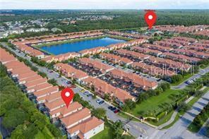 An aerial view shows a residential community with townhomes, a central lake, and a clubhouse — 8985 CUBAN PALM RD. ROAD, KISSIMMEE, FL
