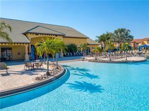 A large swimming pool sits in front of a tan building with palm trees — 8985 CUBAN PALM RD. ROAD, KISSIMMEE, FL