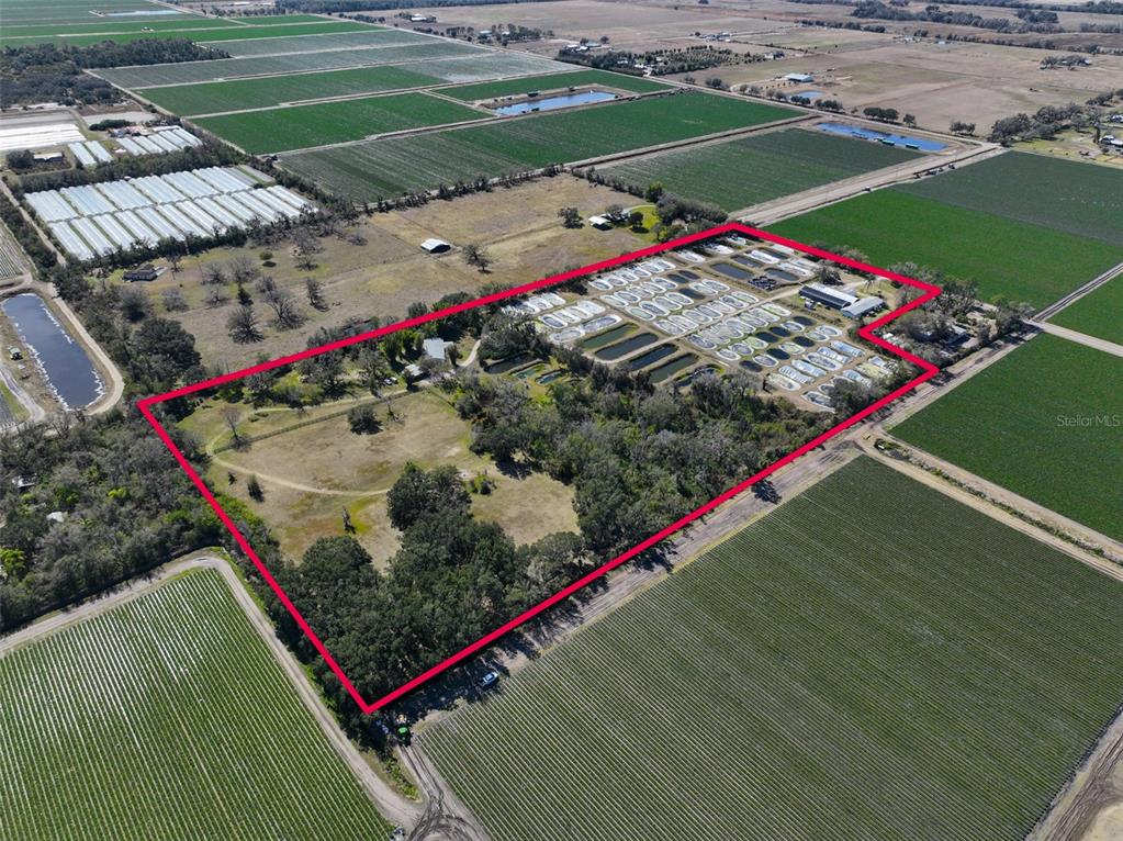 An aerial view shows a rural property with numerous small ponds and agricultural fields — 20112 HOBBS ROAD, WIMAUMA, FL
