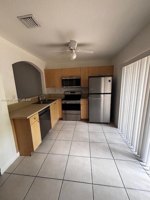 A kitchen features light wood cabinets, stainless steel appliances, and white tile flooring — 13726 SW 171st Ln, Miami FL 33177, MIAMI, FL