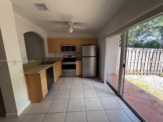 A kitchen with light wood cabinets, stainless steel appliances, and a sliding glass door — 13726 SW 171st Ln, Miami FL 33177, MIAMI, FL