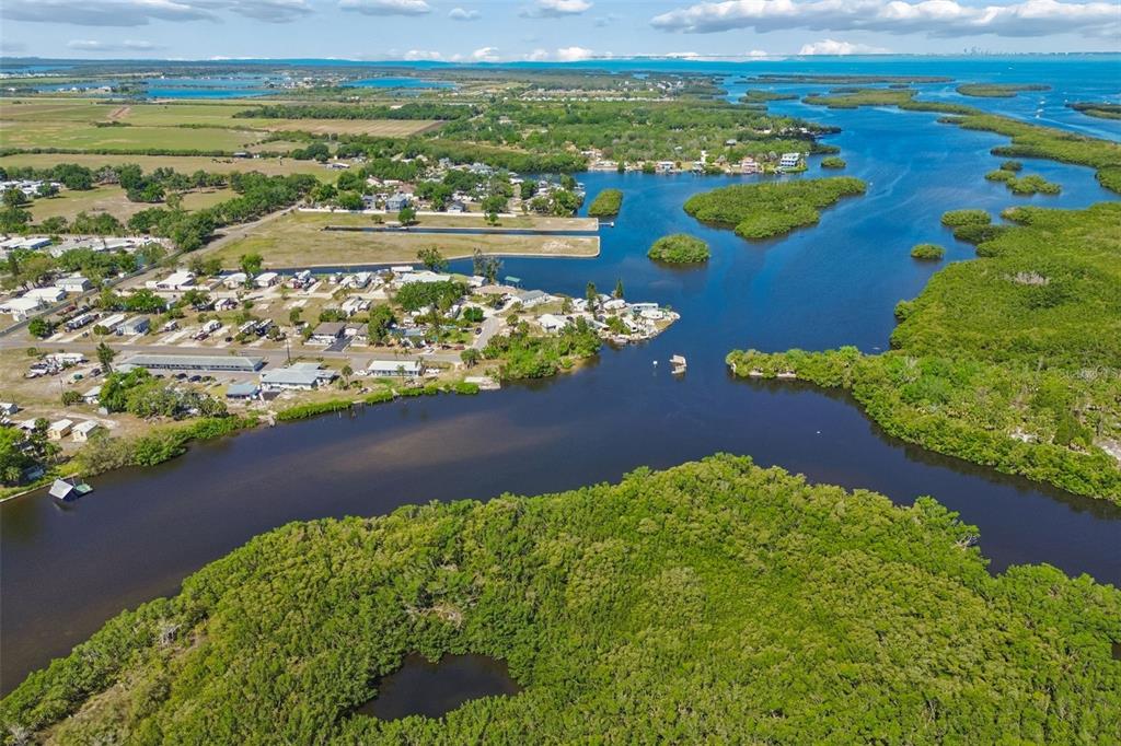 An aerial view shows a coastal community surrounded by dense mangroves and winding waterways — 1130 SWEENEY DRIVE, RUSKIN, FL