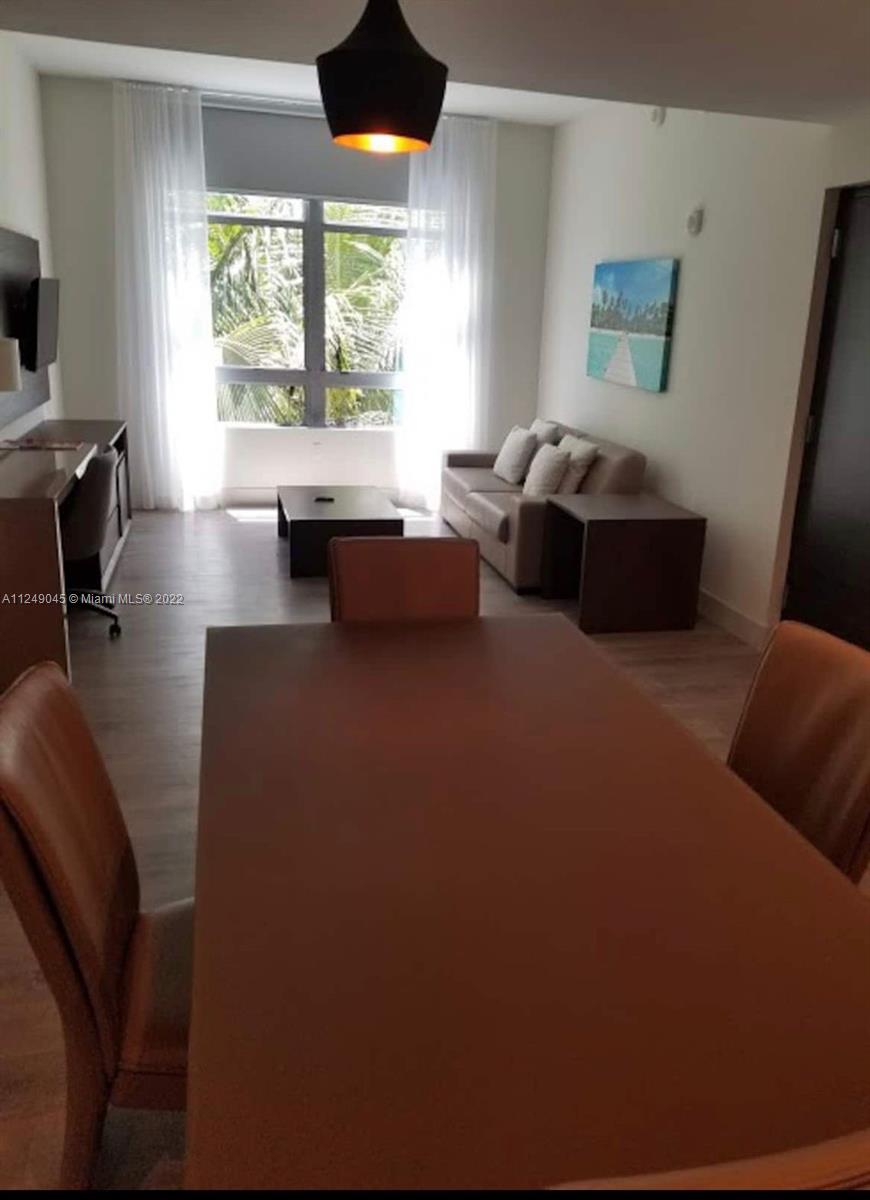 This living and dining area features a dining table, a sofa, and a large window — 777 N Ocean Dr # N323, Hollywood FL 33019, HOLLYWOOD, FL