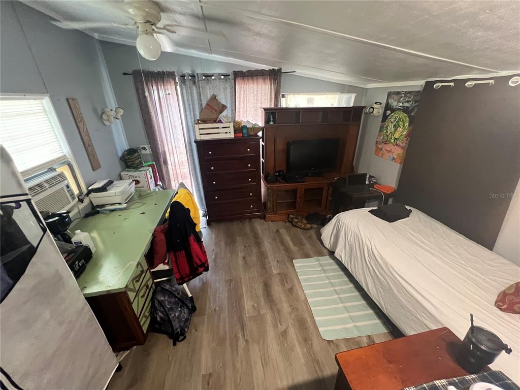 A bedroom with light wood-look flooring, a desk, a dresser, and a single bed — 6724 COUNTY ROAD 214, KEYSTONE HEIGHTS, FL