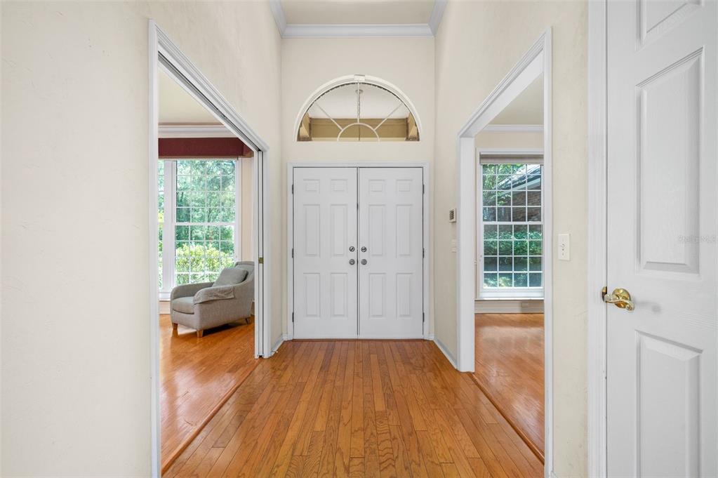 A bright entryway features double front doors, a transom window, and hardwood flooring — 3627 NW 33RD TERRACE, GAINESVILLE, FL