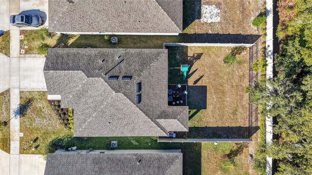 An aerial view shows a residential house with a shingled roof and a fenced backyard — 33692 SKY BLOSSOM CIRCLE, LEESBURG, FL