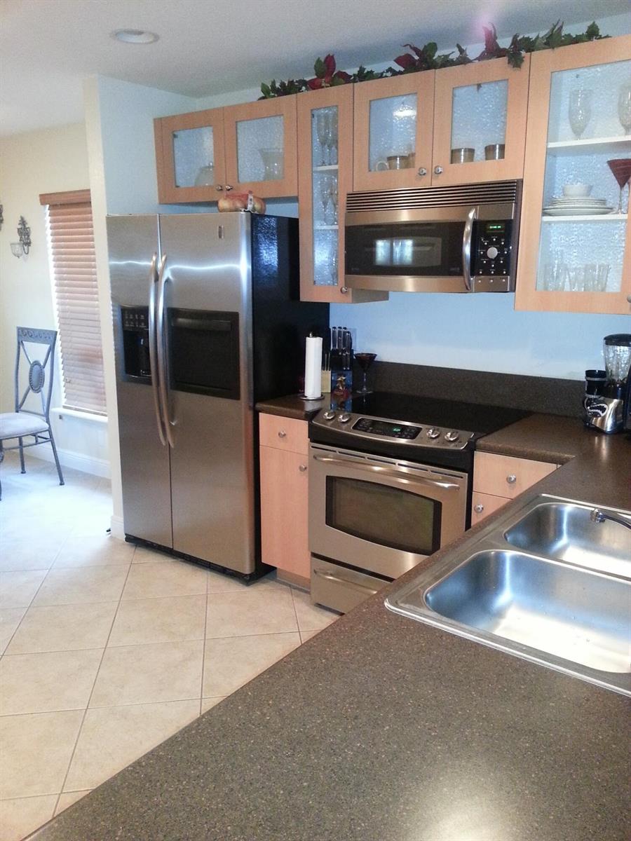 A kitchen features stainless steel appliances, light wood cabinets, and dark countertops — 10012 SW 23rd Street, Miramar FL 33025, MIRAMAR, FL
