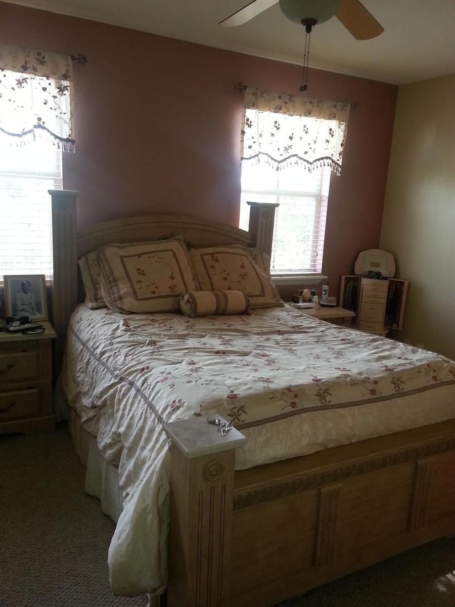 A bedroom features a wooden bed frame, floral bedding, and two windows with valances — 10012 SW 23rd Street, Miramar FL 33025, MIRAMAR, FL