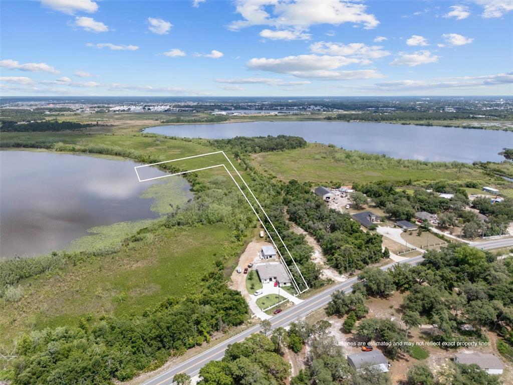 An aerial view shows a house on a lot bordering a lake and a road — 0 POLK CITY ROAD, HAINES CITY, FL