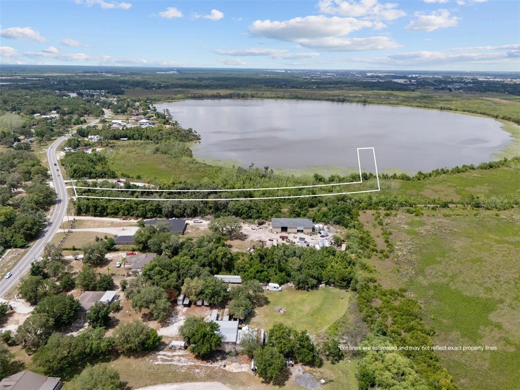 An aerial view shows a property outline extending toward a lake near a road — 0 POLK CITY ROAD, HAINES CITY, FL