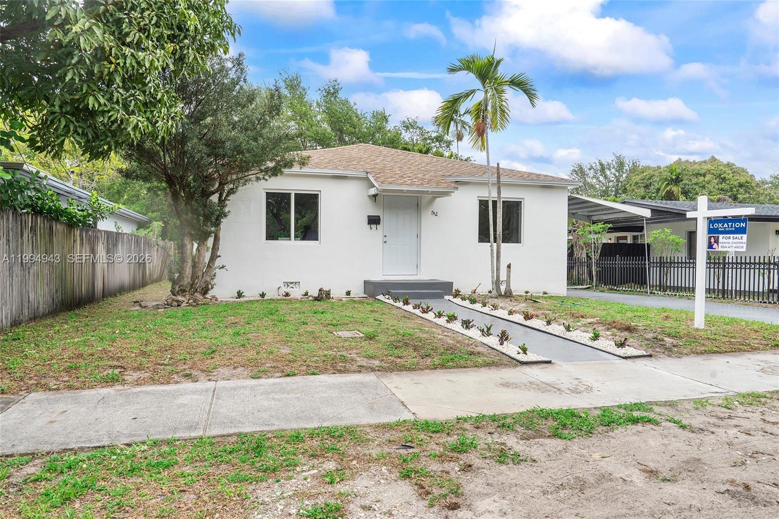 A single-story white house with a brown roof, a palm tree, and a for-sale sign — 511 NE 131st St, North Miami FL 33161, NORTH MIAMI, FL