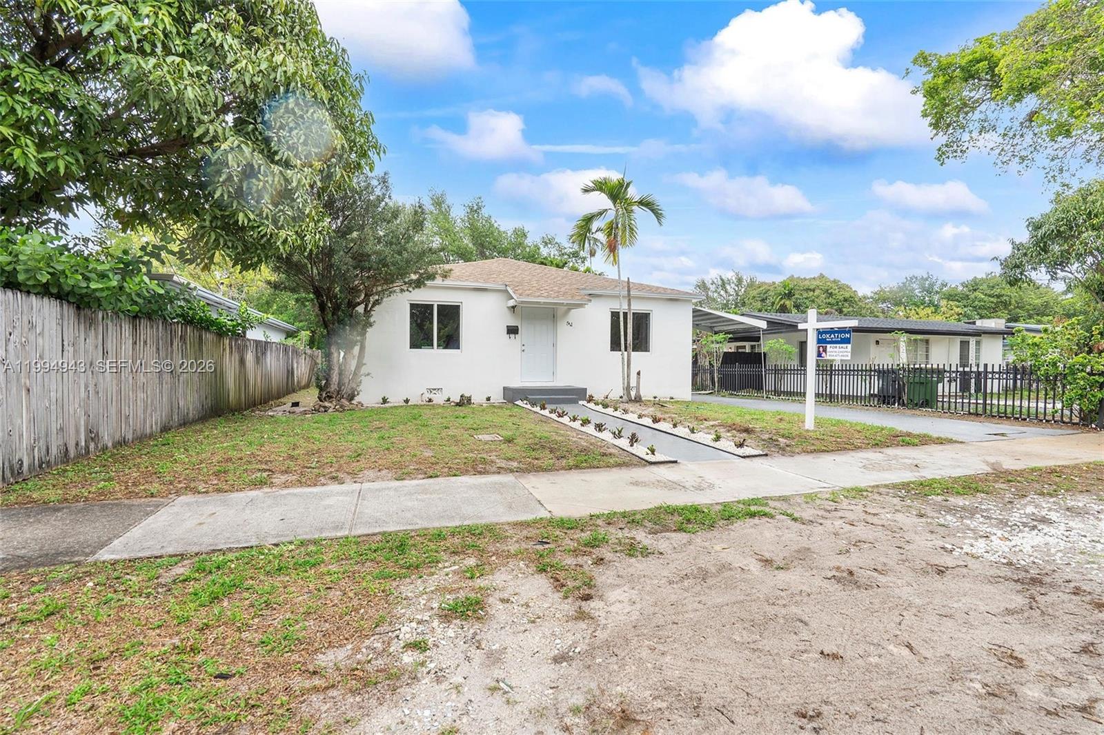 A white single-story house with a front walkway and a yard under a blue sky — 511 NE 131st St, North Miami FL 33161, NORTH MIAMI, FL