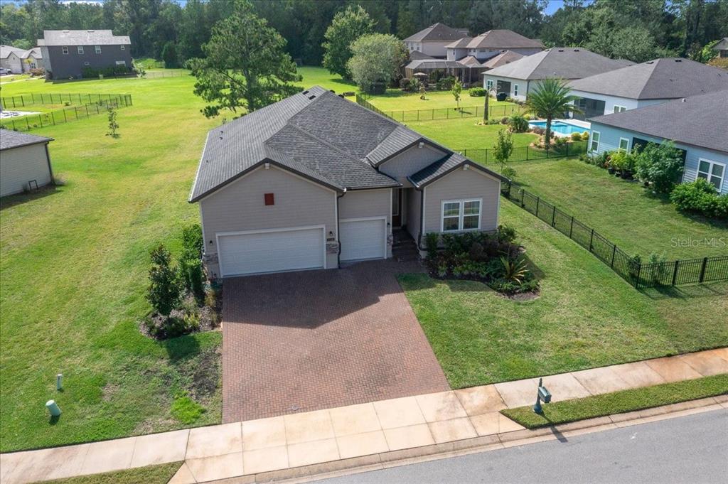 An aerial view shows a single-story house with a brick driveway and a fenced backyard — 1130 SE 42ND ROAD, OCALA, FL